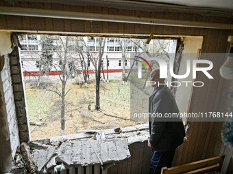 A man stands in front of a knocked-out window in a room of a hostel where internally displaced persons live, damaged by an overnight Russian...