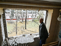 A man stands in front of a knocked-out window in a room of a hostel where internally displaced persons live, damaged by an overnight Russian...