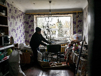 In Zaporizhzhia, Ukraine, on November 11, 2024, a woman tidies a room in a hostel where internally displaced persons live that is damaged by...