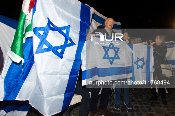 People hold Israeli flags as they attend a demonstration against anti-Semitic violence at Largo Argentina in Rome, Italy, on November 11, 20...