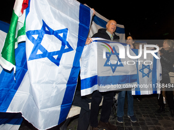 People hold Israeli flags as they attend a demonstration against anti-Semitic violence at Largo Argentina in Rome, Italy, on November 11, 20...