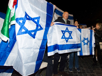 People hold Israeli flags as they attend a demonstration against anti-Semitic violence at Largo Argentina in Rome, Italy, on November 11, 20...