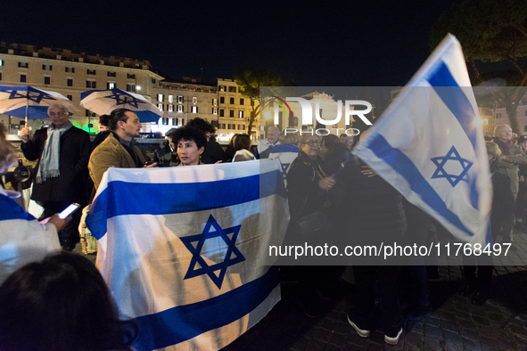 People hold Israeli flags as they attend a demonstration against anti-Semitic violence at Largo Argentina in Rome, Italy, on November 11, 20...