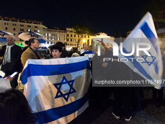 People hold Israeli flags as they attend a demonstration against anti-Semitic violence at Largo Argentina in Rome, Italy, on November 11, 20...