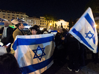 People hold Israeli flags as they attend a demonstration against anti-Semitic violence at Largo Argentina in Rome, Italy, on November 11, 20...