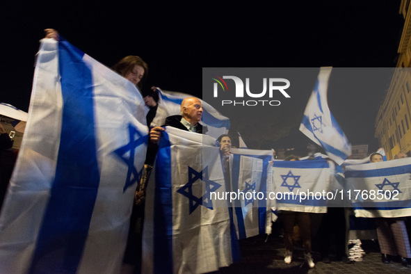 People hold Israeli flags as they attend a demonstration against anti-Semitic violence at Largo Argentina in Rome, Italy, on November 11, 20...