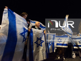 People hold Israeli flags as they attend a demonstration against anti-Semitic violence at Largo Argentina in Rome, Italy, on November 11, 20...