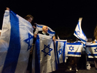 People hold Israeli flags as they attend a demonstration against anti-Semitic violence at Largo Argentina in Rome, Italy, on November 11, 20...