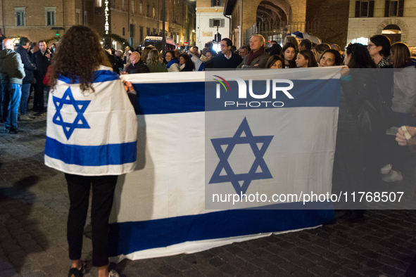 People hold Israeli flags as they attend a demonstration against anti-Semitic violence at Largo Argentina in Rome, Italy, on November 11, 20...