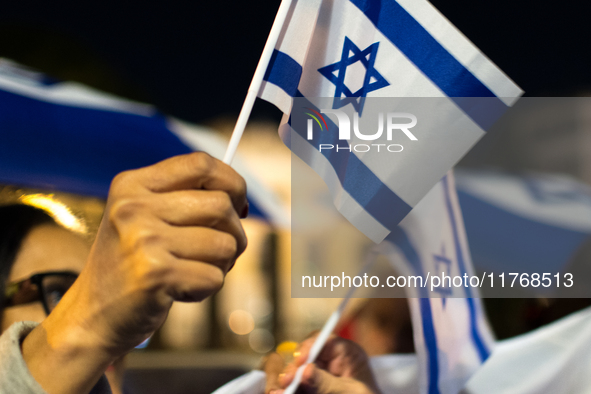 People hold Israeli flags as they attend a demonstration against anti-Semitic violence at Largo Argentina in Rome, Italy, on November 11, 20...