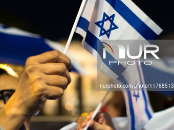 People hold Israeli flags as they attend a demonstration against anti-Semitic violence at Largo Argentina in Rome, Italy, on November 11, 20...