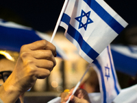 People hold Israeli flags as they attend a demonstration against anti-Semitic violence at Largo Argentina in Rome, Italy, on November 11, 20...