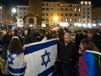 People hold Israeli flags as they attend a demonstration against anti-Semitic violence at Largo Argentina in Rome, Italy, on November 11, 20...