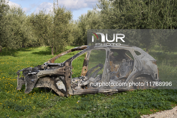 A burnt and abandoned stolen car rests in the rural fields near Cerignola, Italy, on October 4, 2024. The vehicle, stripped of all valuables...