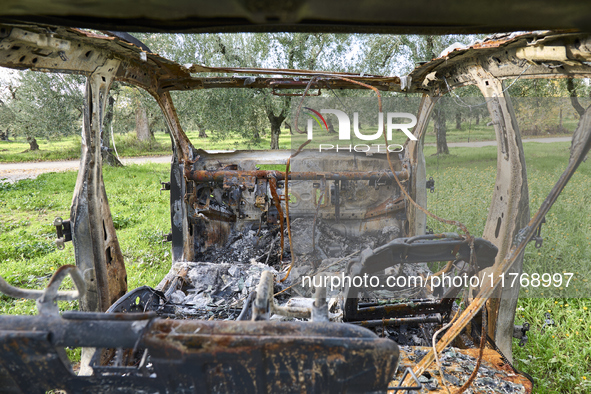 A burnt and abandoned stolen car rests in the rural fields near Cerignola, Italy, on October 4, 2024. The vehicle, stripped of all valuables...