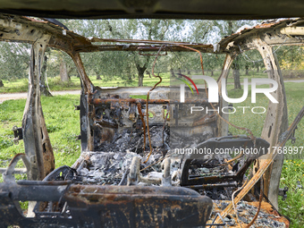 A burnt and abandoned stolen car rests in the rural fields near Cerignola, Italy, on October 4, 2024. The vehicle, stripped of all valuables...