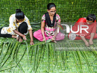 Women weave coconut leaves to prepare a traditional decorative background for the upcoming wedding season at a street side in Hyderabad, Ind...