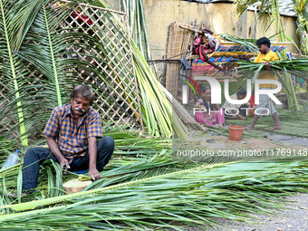 A man cuts coconut leaves for the preparation of a traditional decorative background for the upcoming wedding season at a street side in Hyd...