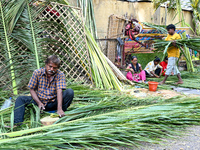 A man cuts coconut leaves for the preparation of a traditional decorative background for the upcoming wedding season at a street side in Hyd...