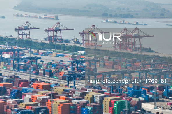 Cargo ships load and unload at berths, and trucks shuttle in the yard at Longtan Port area of Nanjing Port in Nanjing, Jiangsu province, Chi...