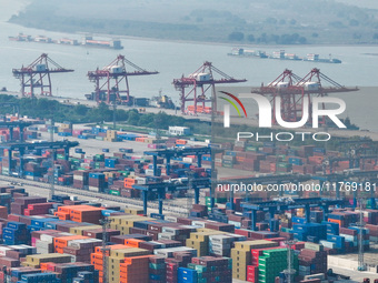 Cargo ships load and unload at berths, and trucks shuttle in the yard at Longtan Port area of Nanjing Port in Nanjing, Jiangsu province, Chi...