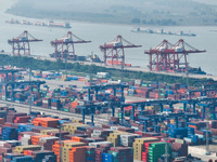 Cargo ships load and unload at berths, and trucks shuttle in the yard at Longtan Port area of Nanjing Port in Nanjing, Jiangsu province, Chi...