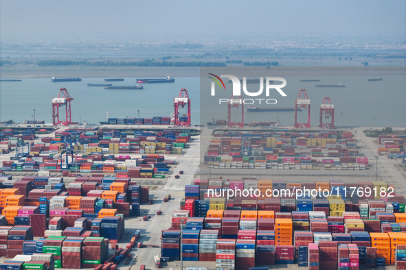 Cargo ships load and unload at berths, and trucks shuttle in the yard at Longtan Port area of Nanjing Port in Nanjing, Jiangsu province, Chi...