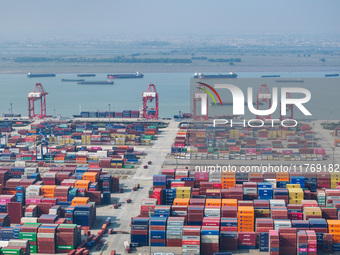 Cargo ships load and unload at berths, and trucks shuttle in the yard at Longtan Port area of Nanjing Port in Nanjing, Jiangsu province, Chi...