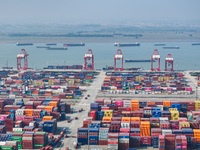 Cargo ships load and unload at berths, and trucks shuttle in the yard at Longtan Port area of Nanjing Port in Nanjing, Jiangsu province, Chi...