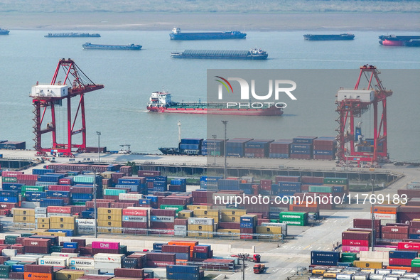 Cargo ships load and unload at berths, and trucks shuttle in the yard at Longtan Port area of Nanjing Port in Nanjing, Jiangsu province, Chi...