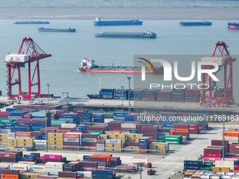 Cargo ships load and unload at berths, and trucks shuttle in the yard at Longtan Port area of Nanjing Port in Nanjing, Jiangsu province, Chi...