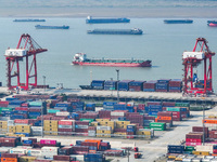 Cargo ships load and unload at berths, and trucks shuttle in the yard at Longtan Port area of Nanjing Port in Nanjing, Jiangsu province, Chi...