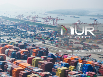 Cargo ships load and unload at berths, and trucks shuttle in the yard at Longtan Port area of Nanjing Port in Nanjing, Jiangsu province, Chi...