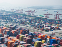 Cargo ships load and unload at berths, and trucks shuttle in the yard at Longtan Port area of Nanjing Port in Nanjing, Jiangsu province, Chi...