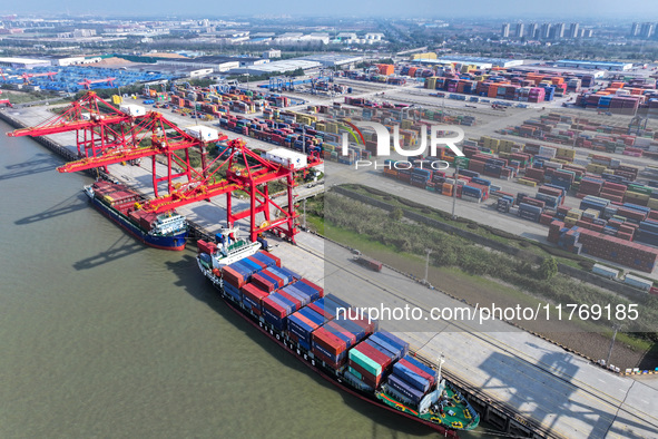 Cargo ships load and unload at berths, and trucks shuttle in the yard at Longtan Port area of Nanjing Port in Nanjing, Jiangsu province, Chi...