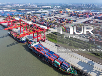 Cargo ships load and unload at berths, and trucks shuttle in the yard at Longtan Port area of Nanjing Port in Nanjing, Jiangsu province, Chi...