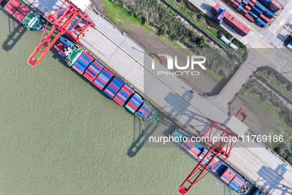 Cargo ships load and unload at berths, and trucks shuttle in the yard at Longtan Port area of Nanjing Port in Nanjing, Jiangsu province, Chi...