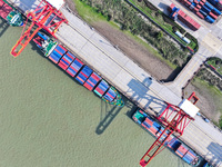 Cargo ships load and unload at berths, and trucks shuttle in the yard at Longtan Port area of Nanjing Port in Nanjing, Jiangsu province, Chi...