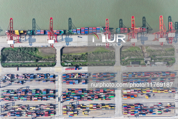 Cargo ships load and unload at berths, and trucks shuttle in the yard at Longtan Port area of Nanjing Port in Nanjing, Jiangsu province, Chi...