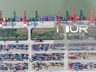 Cargo ships load and unload at berths, and trucks shuttle in the yard at Longtan Port area of Nanjing Port in Nanjing, Jiangsu province, Chi...