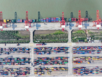 Cargo ships load and unload at berths, and trucks shuttle in the yard at Longtan Port area of Nanjing Port in Nanjing, Jiangsu province, Chi...