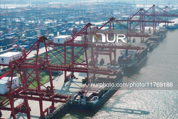 Cargo ships load and unload at berths, and trucks shuttle in the yard at Longtan Port area of Nanjing Port in Nanjing, Jiangsu province, Chi...