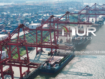 Cargo ships load and unload at berths, and trucks shuttle in the yard at Longtan Port area of Nanjing Port in Nanjing, Jiangsu province, Chi...