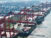 Cargo ships load and unload at berths, and trucks shuttle in the yard at Longtan Port area of Nanjing Port in Nanjing, Jiangsu province, Chi...