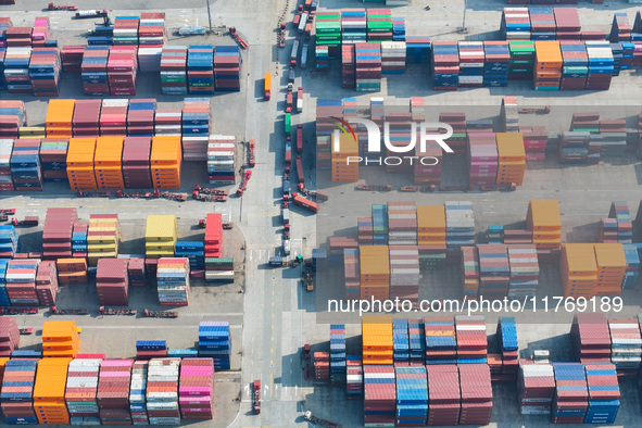 Cargo ships load and unload at berths, and trucks shuttle in the yard at Longtan Port area of Nanjing Port in Nanjing, Jiangsu province, Chi...