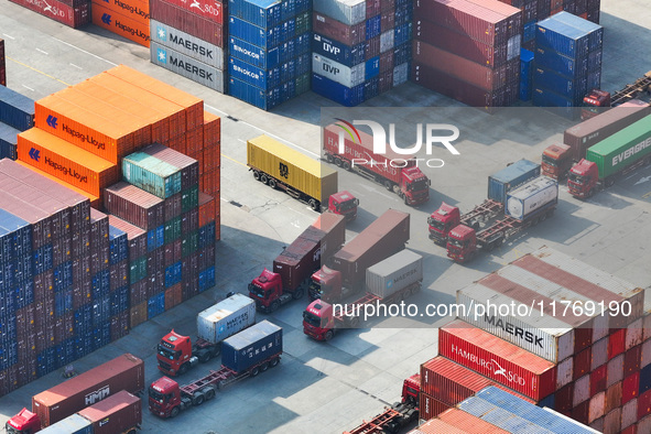 Cargo ships load and unload at berths, and trucks shuttle in the yard at Longtan Port area of Nanjing Port in Nanjing, Jiangsu province, Chi...