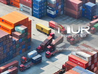 Cargo ships load and unload at berths, and trucks shuttle in the yard at Longtan Port area of Nanjing Port in Nanjing, Jiangsu province, Chi...