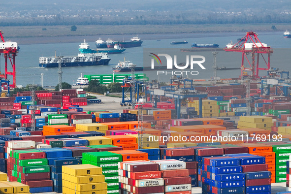 Cargo ships load and unload at berths, and trucks shuttle in the yard at Longtan Port area of Nanjing Port in Nanjing, Jiangsu province, Chi...