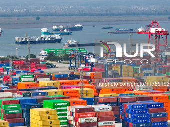 Cargo ships load and unload at berths, and trucks shuttle in the yard at Longtan Port area of Nanjing Port in Nanjing, Jiangsu province, Chi...