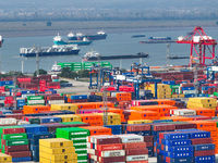 Cargo ships load and unload at berths, and trucks shuttle in the yard at Longtan Port area of Nanjing Port in Nanjing, Jiangsu province, Chi...